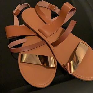 Tan brown sandals with gold accent.